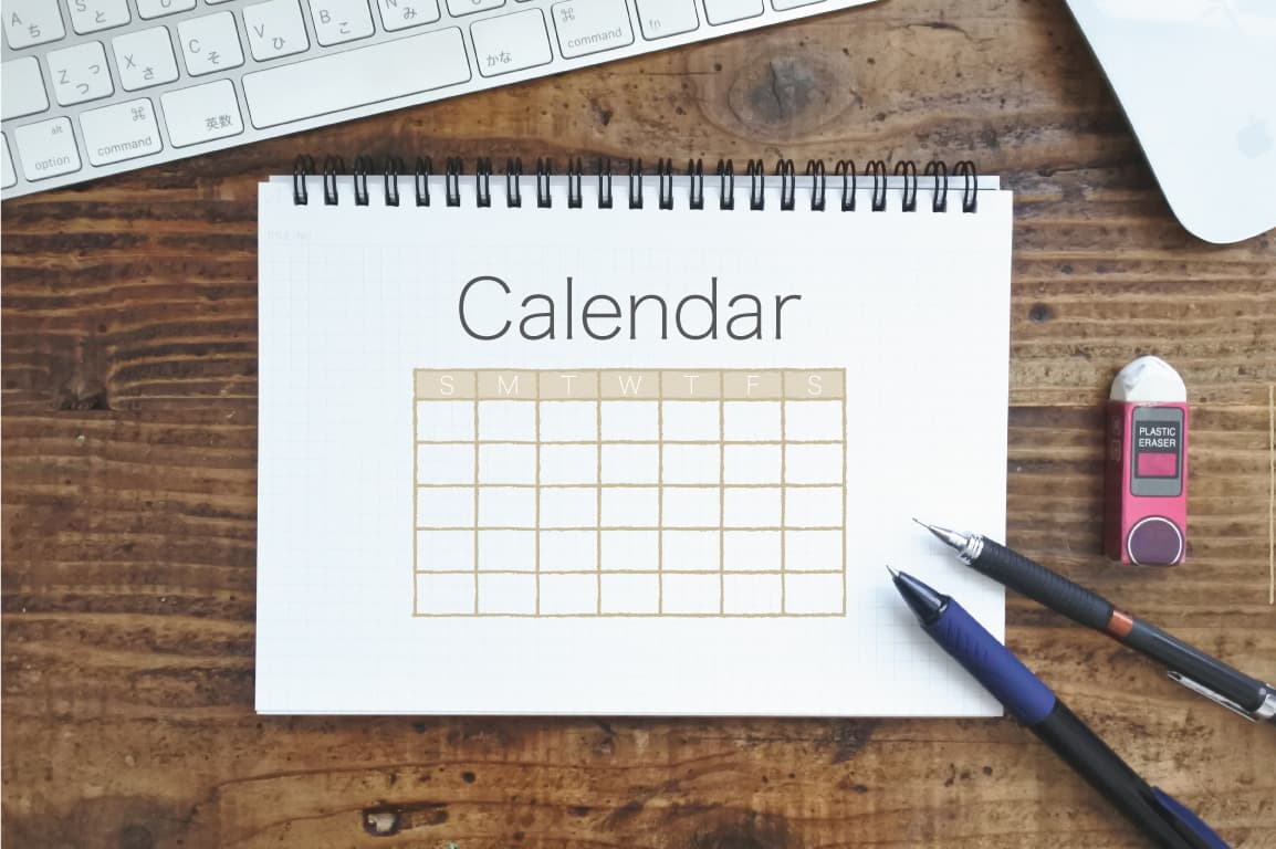 机に置かれた「カレンダー」と書かれたノート